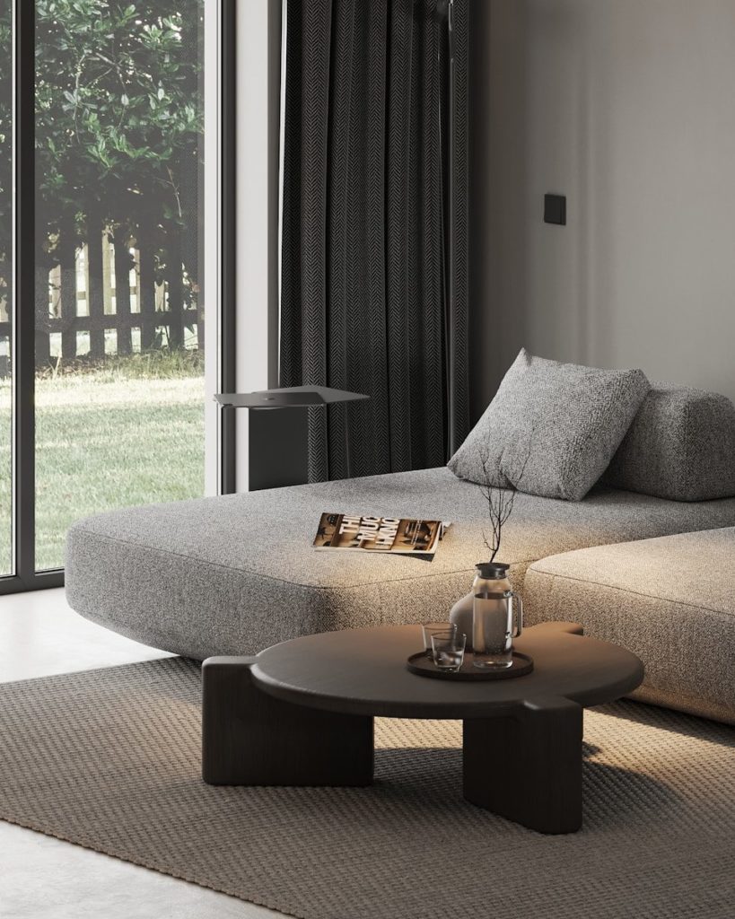 A living room with a couch, coffee table and sliding glass doors